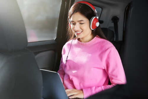 woman watching tv show in car during airport transfer